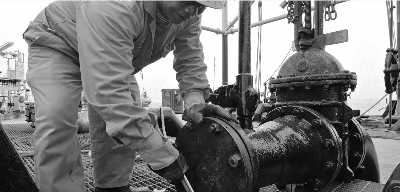 Maintenance technician repairing an industrial valve on an oil and gas platform – illustrating frontline maintenance challenges for asset-intensive industries on reliabilityacademy.com.