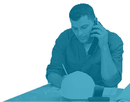 Maintenance supervisor on the phone while reviewing work orders—used in Reliability Academy’s PS300 course on effective scheduling and communication