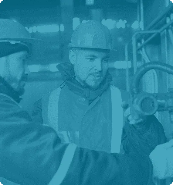 Two maintenance technicians inspecting industrial equipment—representing hands-on training and practical reliability skills taught by Reliability Academy