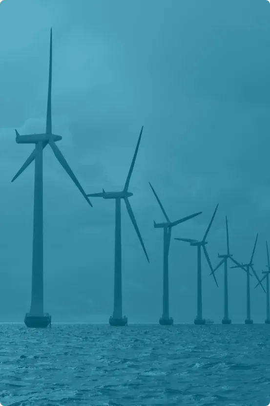 Offshore wind farm with a row of large wind turbines in the ocean under a cloudy sky, representing renewable energy and industrial reliability