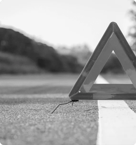 Warning triangle placed on road indicating vehicle breakdown—symbolic of risk and unplanned downtime from reactive maintenance in Reliability Academy training